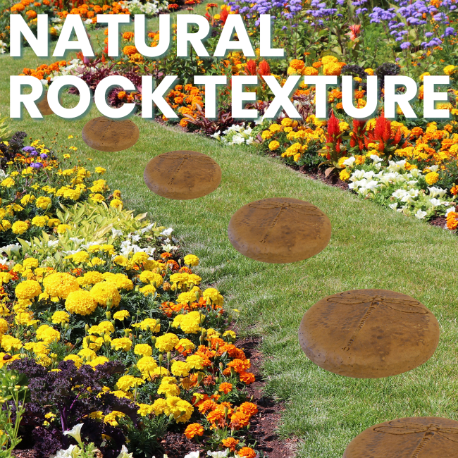 Two handcrafted dragonfly garden stepping stones placed along a colorful garden path with flowers, featuring an autumn wheat finish.