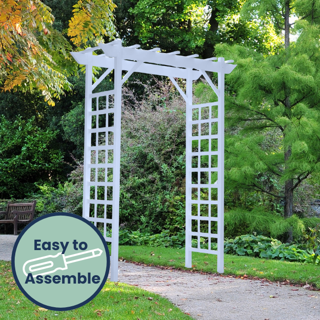 The Vinyl Lattice Arbor standing tall in a beautiful garden, with clean lines, elegant latticework, and a dramatic flat top. This arbor creates a peaceful garden retreat, perfect for climbing vines and flowers